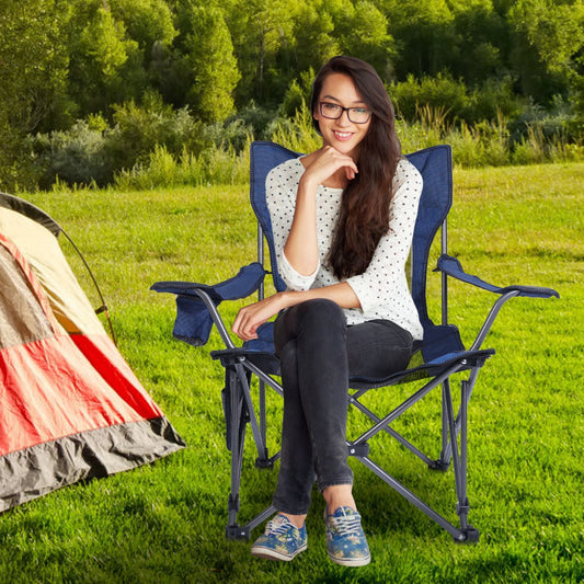 Woman sitting in a camping chair outdoors with a tent in the background