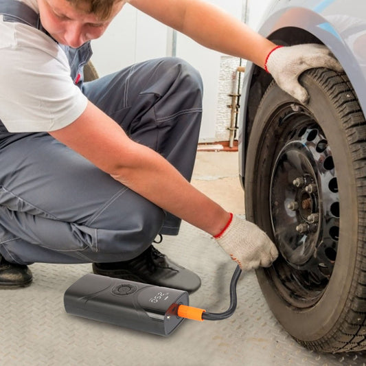 Cordless tire inflator being used on car tire at roadside