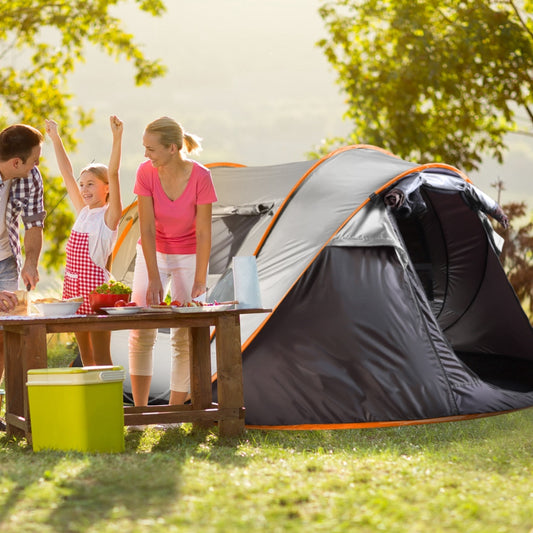 Family preparing food beside a large pop-up tent at an outdoor campsite