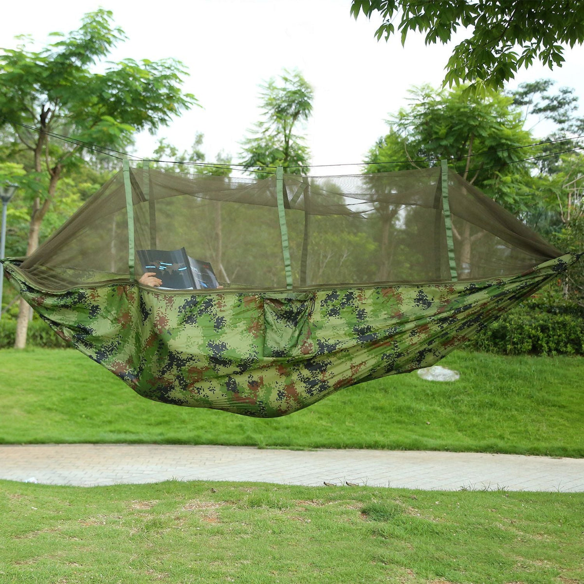 Camouflage hammock with mosquito net in a park setting