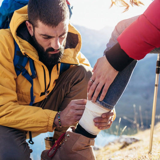 Outdoor bandaging of a lower leg during a hiking break