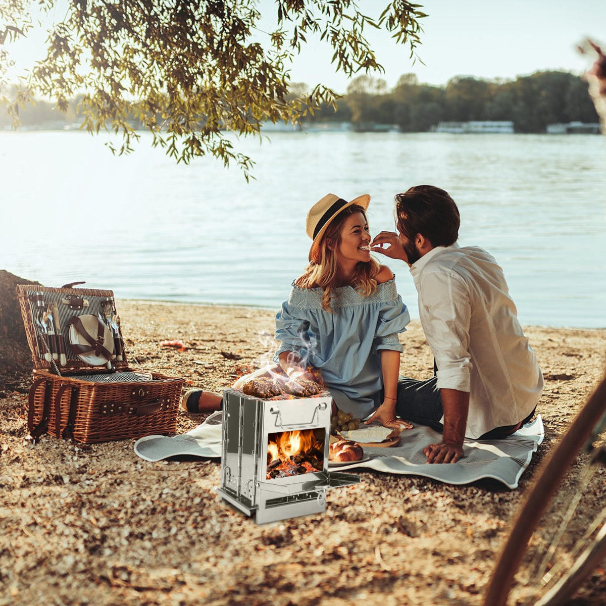 Couple having a picnic by a lake with a portable stove.