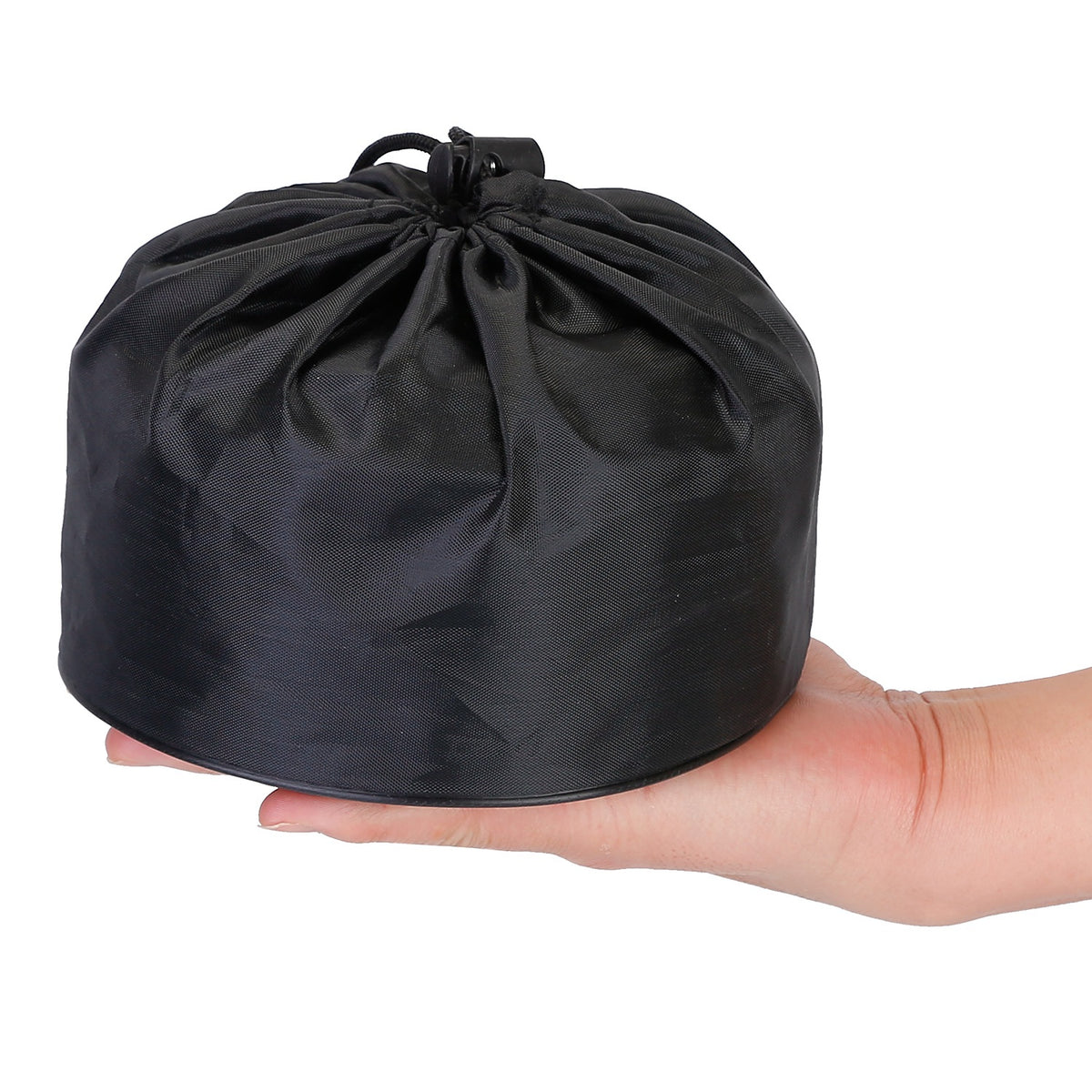 Black drawstring bag held in a hand against a white background