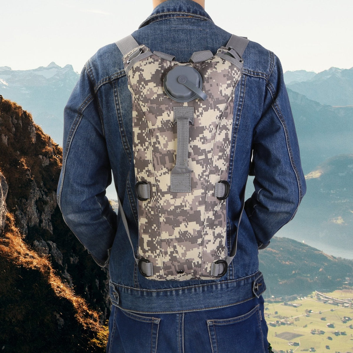 Person wearing a camouflage hydration backpack with a mountainous landscape in the background