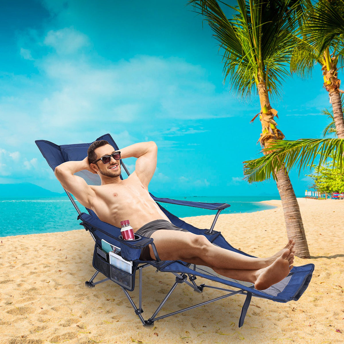 Man relaxing on a beach chair under a palm tree with a clear blue sky.