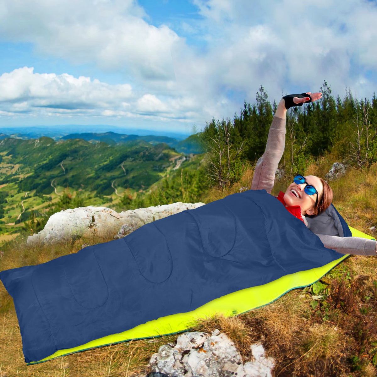Person lying on a sleeping bag with a scenic mountain view in the background