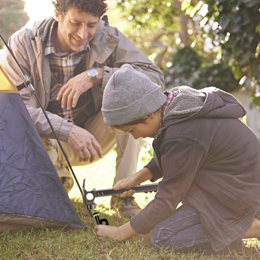 Man and child setting up a tent outdoors