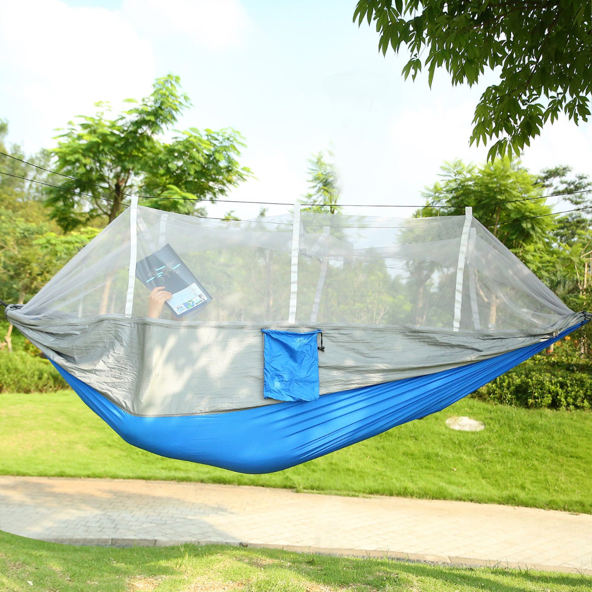 Blue hammock with mosquito net in a park setting