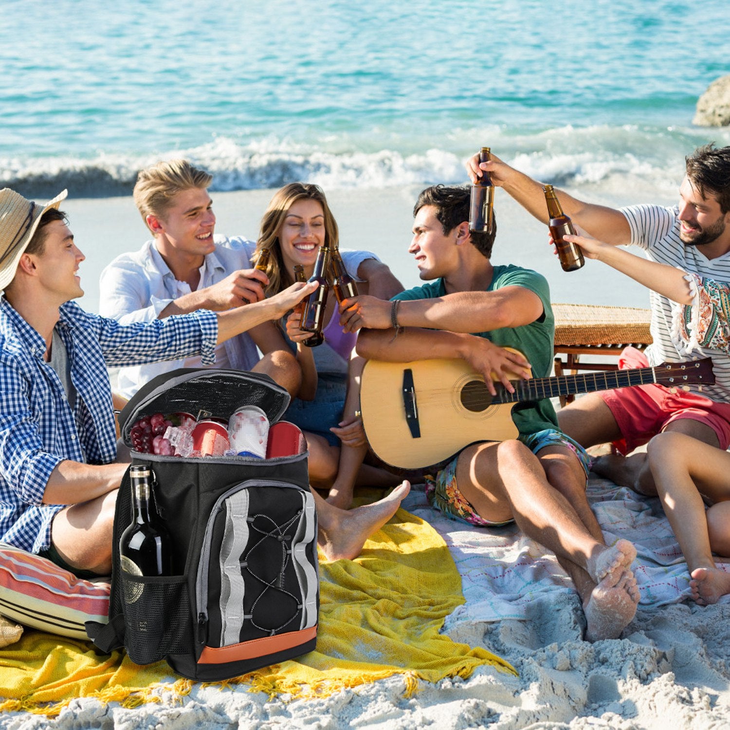 Group of friends enjoying a beach day with music and drinks.