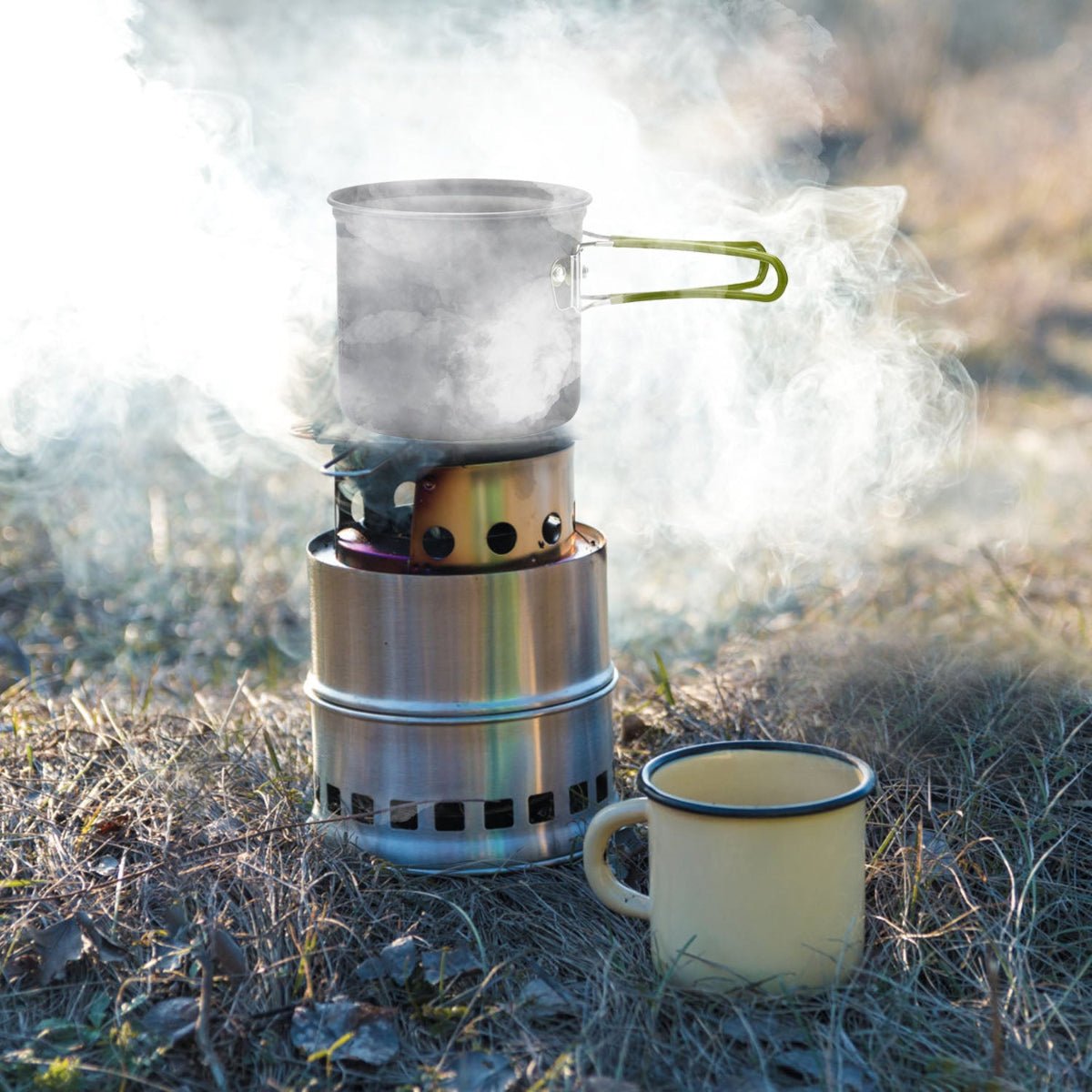 Aluminum camping pot boiling on outdoor stove with steam rising from water