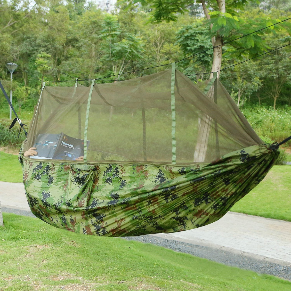 Camouflage hammock with mosquito net in a forest setting