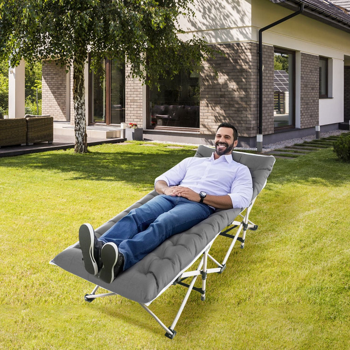 Man relaxing on a portable outdoor bed in a garden.