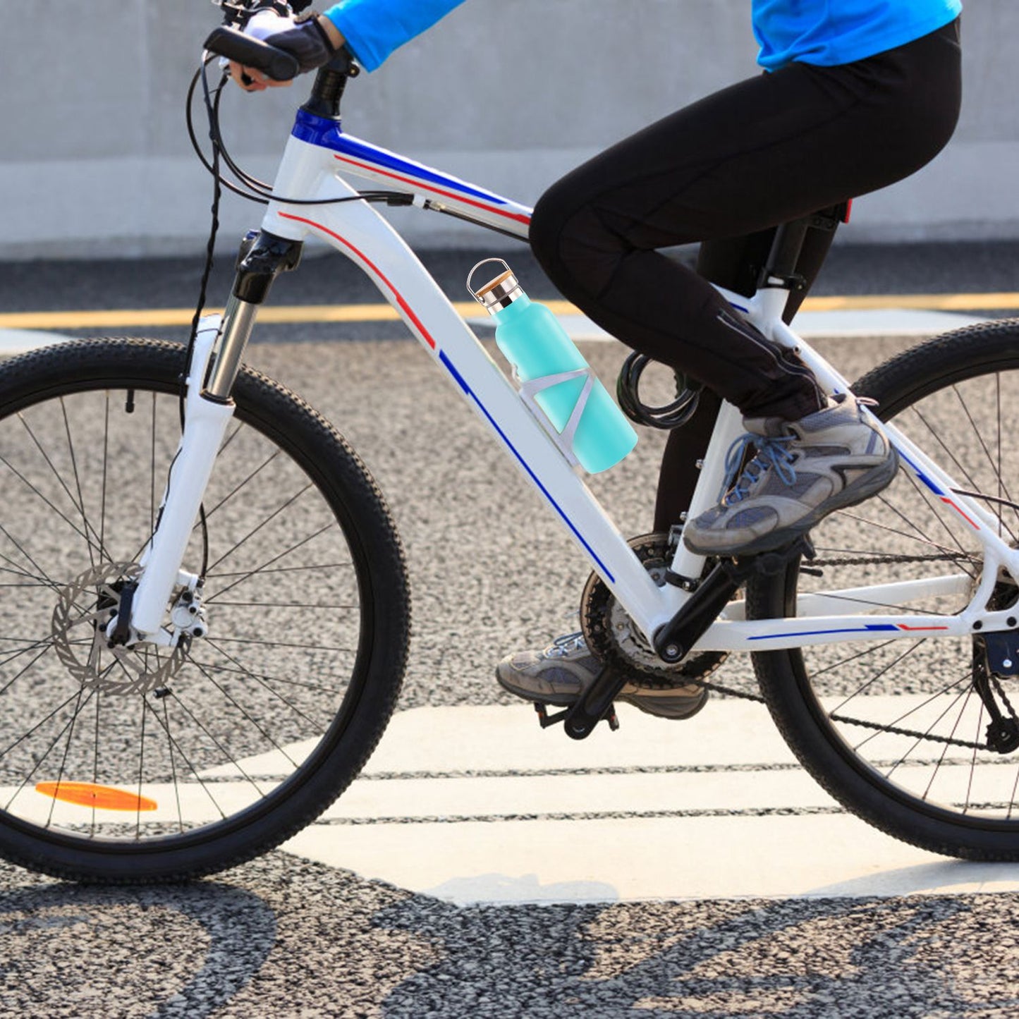 Person riding a bicycle with a blue water bottle on a road