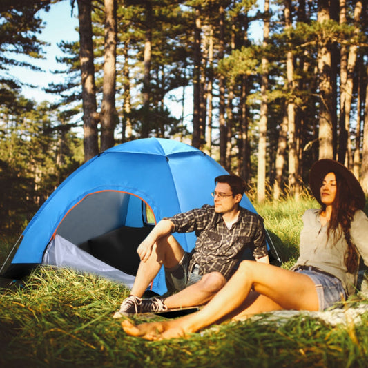 Blue pop up camping tent set up in a forest clearing with two adults seated nearby