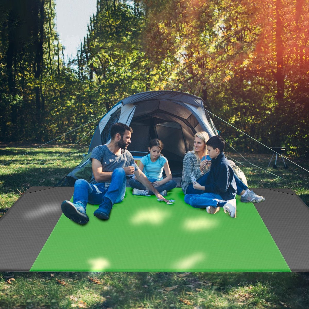 People seated on foldable outdoor mat at a campsite