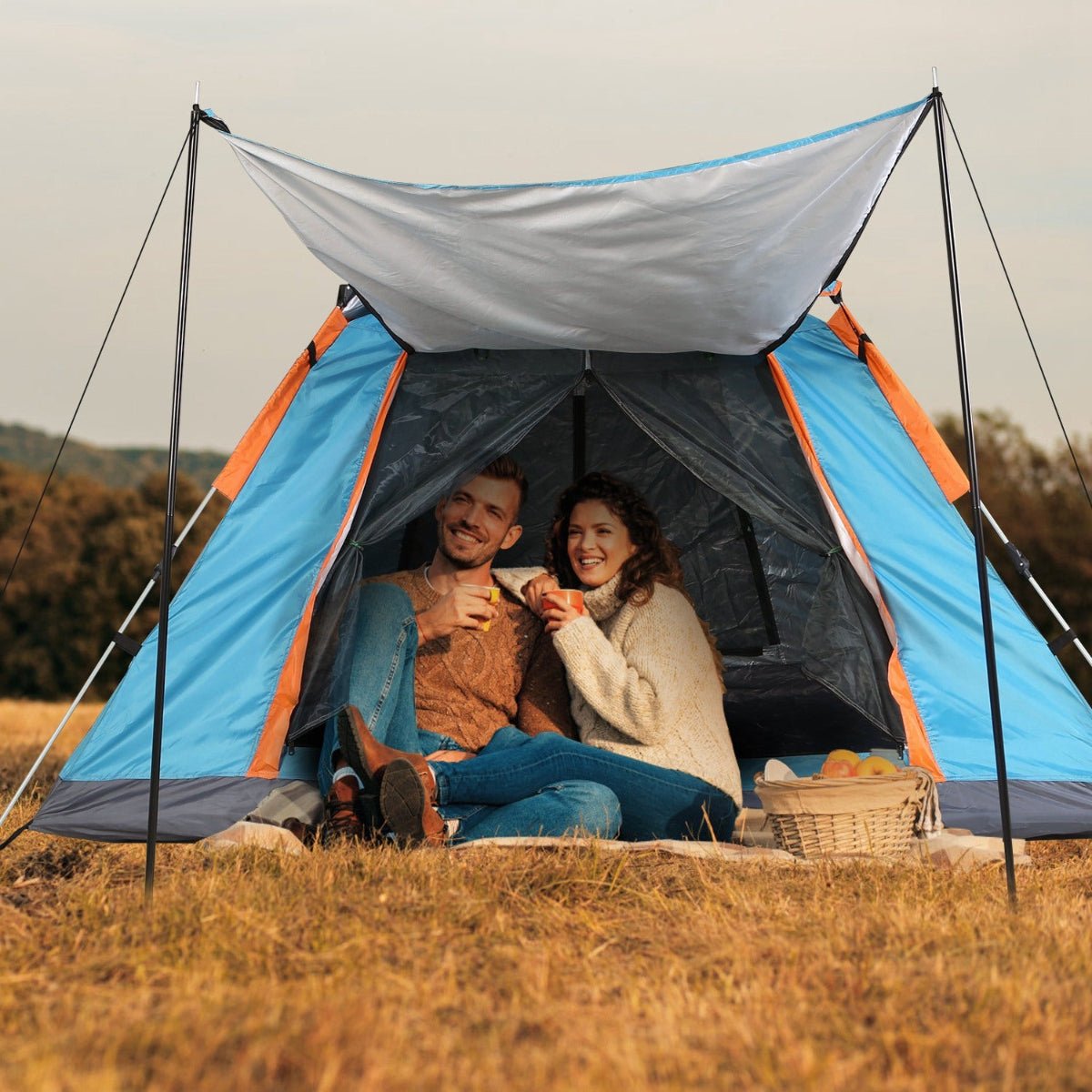 Front view of camping tent with canopy extended and people sitting inside