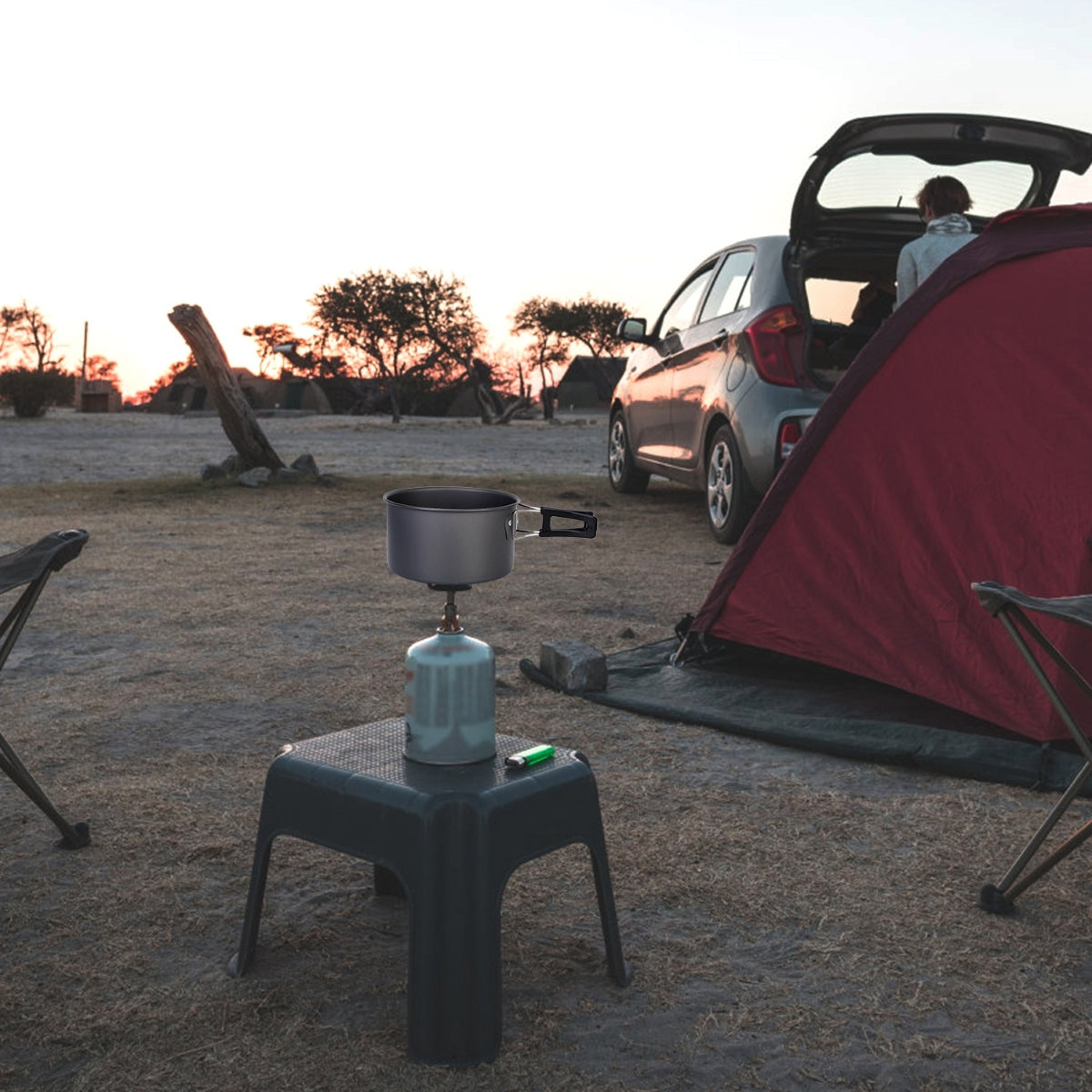 Camping pot on portable stove beside tent at sunset campsite