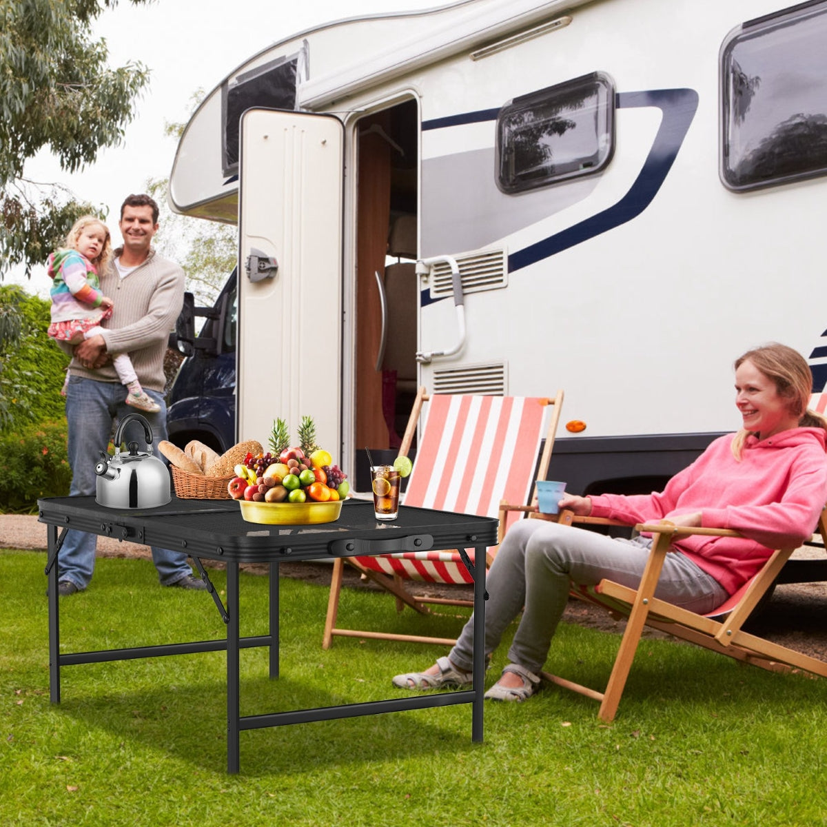 Portable mesh camping table in front of RV with seated family
