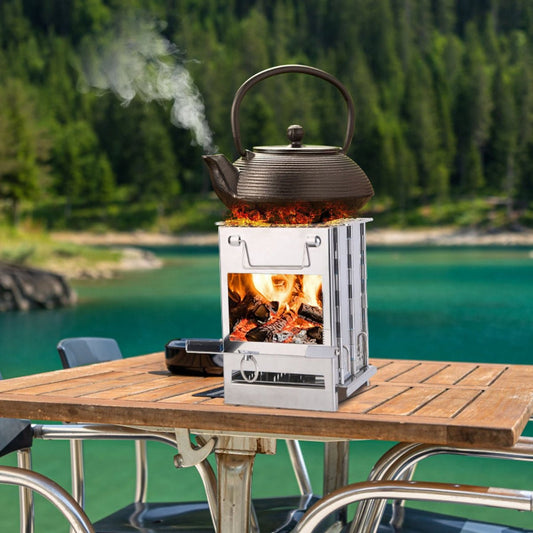 Compact stainless steel backpacking stove heating a kettle on an outdoor table by a lake