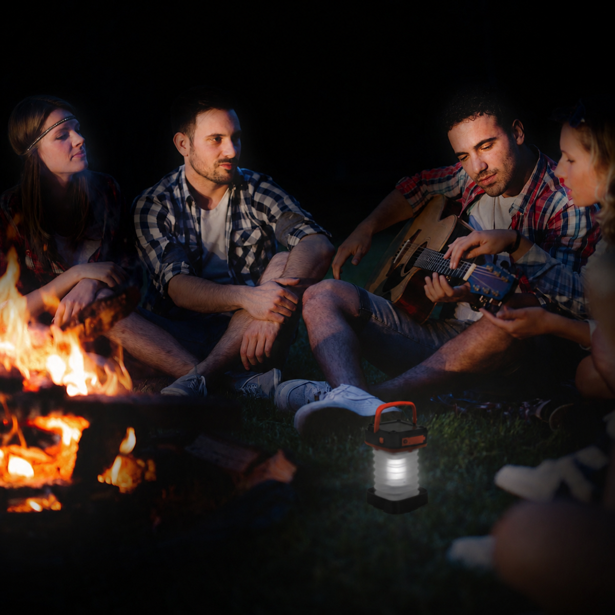 Group of friends sitting around a campfire at night, playing guitar and enjoying each other's company.