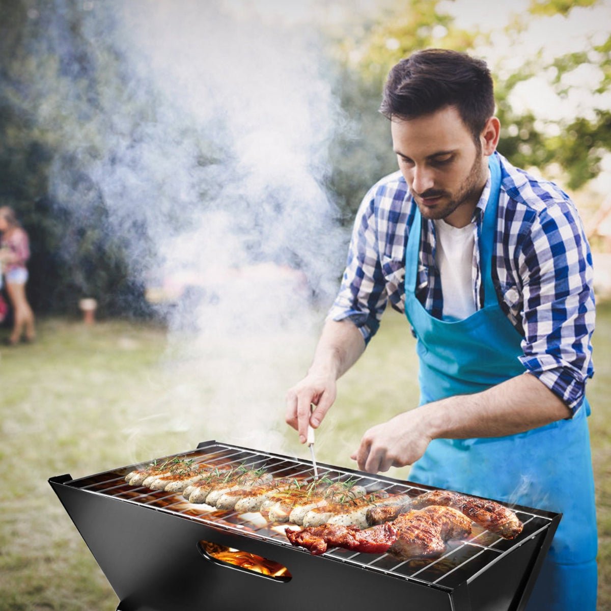 Person grilling food outdoors using a portable foldable charcoal grill