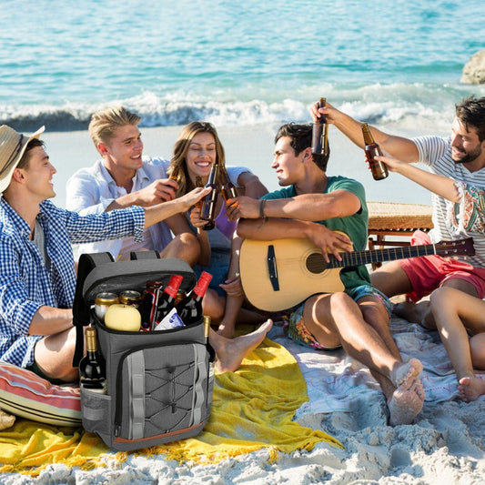 Cooler backpack on beach blanket with group seated near shoreline